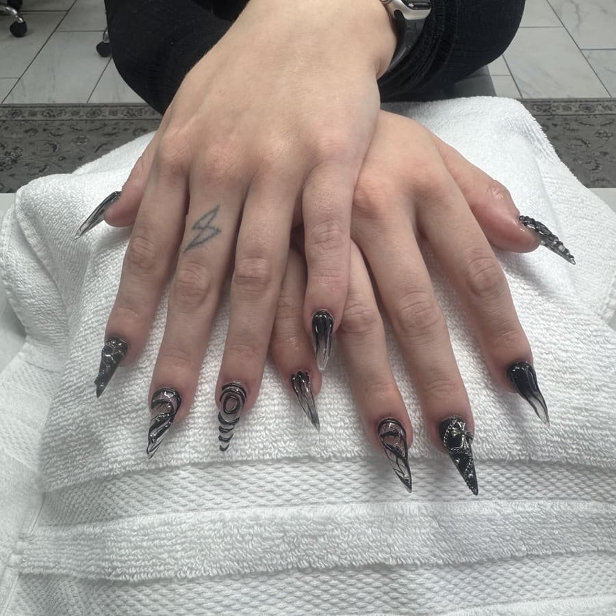 Black stiletto nails with hand-drawn nail art