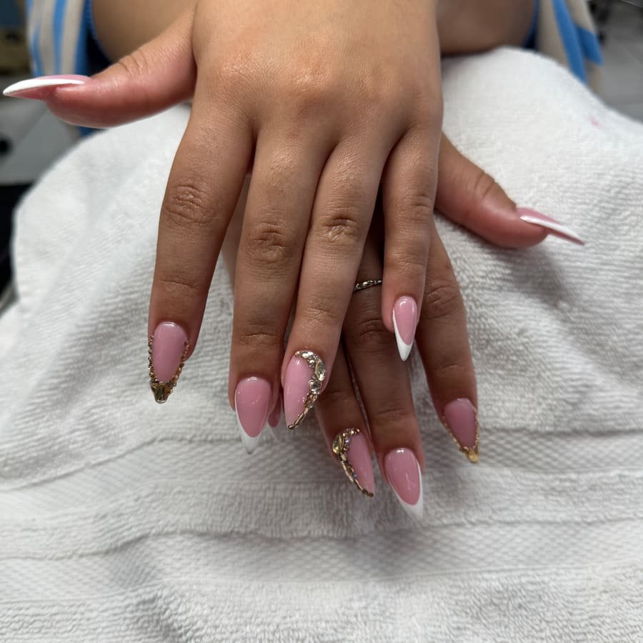 Pink almond nails with gold French tips and gold rhinestones