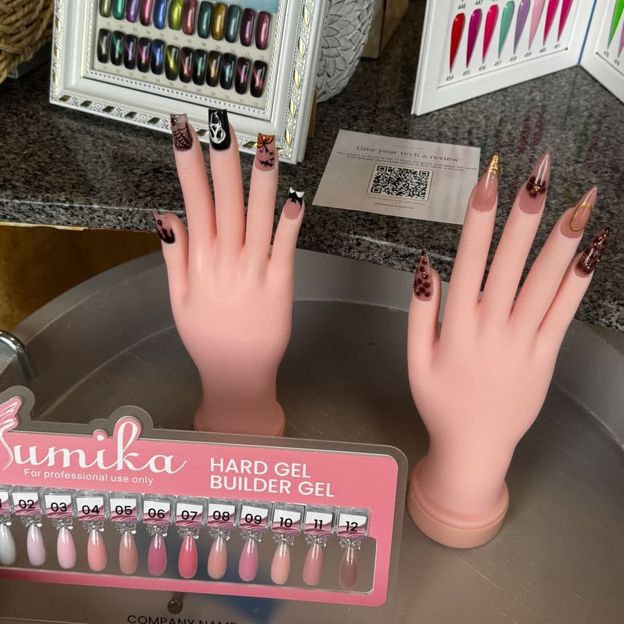 Nail art samples on display hands next to a builder gel color chart