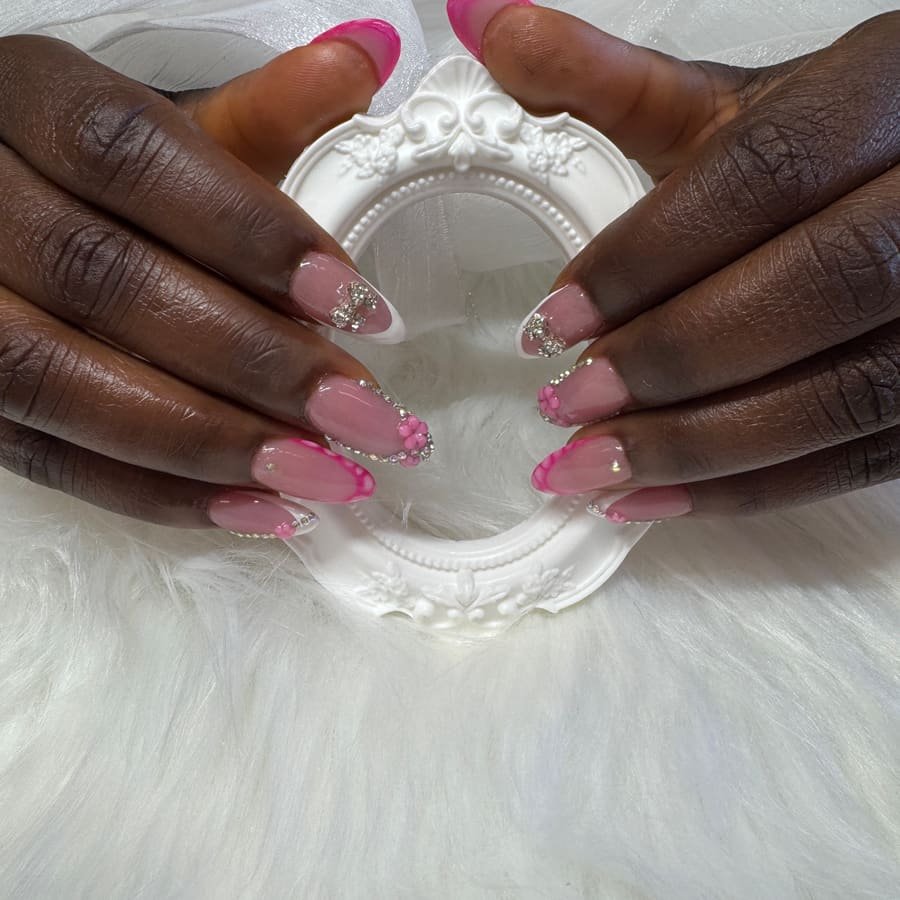 Pink French tip nails with rhinestone accents