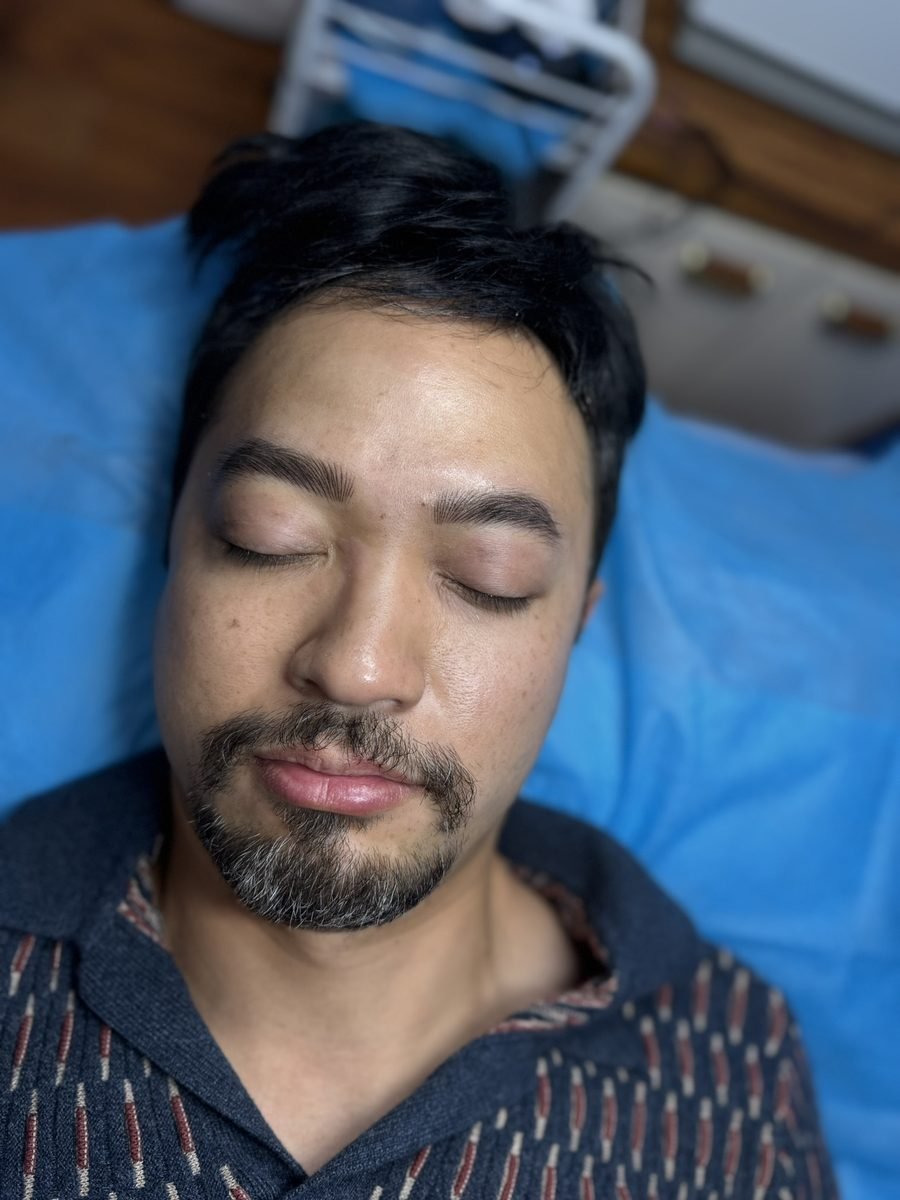Nano hairstroke brows on a male client lying down